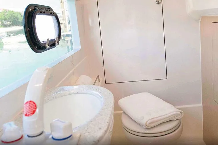 Slide: The Image of Manufacturer Provided Image: 2023 Aquila 36 Sport yacht bathroom with sink, toilet, and porthole window. - 54