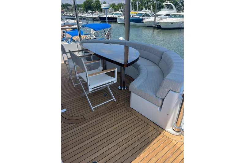 Slide: The Image of 2011 Hatteras yacht helm with Garmin navigation, white seating, and modern controls. - 15
