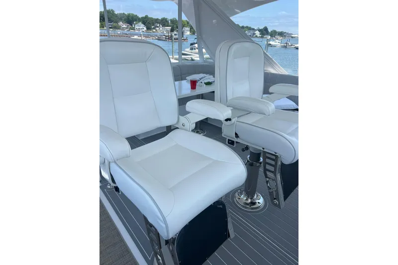 Slide: The Image of Luxurious 2011 Hatteras yacht interior with seating and clear enclosures, docked near waterfront homes. - 17