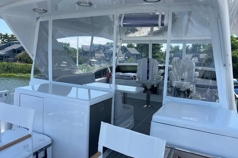 Slide: The Image of 2011 Hatteras 60 Motor Yacht on serene water, sunny day, lush greenery in background. - 4