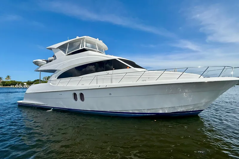 Slide: The Image of 2011 Hatteras 60 Motor Yacht cruising on a sunny day, surrounded by lush greenery. - 49