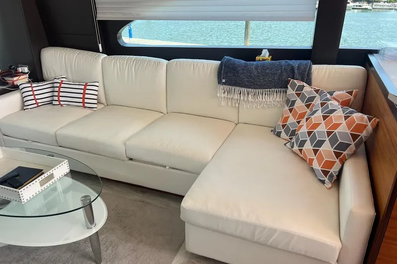 Slide: The Image of 2011 Hatteras 60 Motor Yacht cruising on a sunny day, surrounded by calm waters and lush greenery. - 7