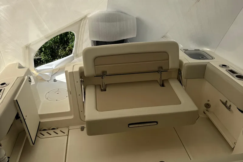 Slide: The Image of 2022 Boston Whaler 240 Vantage interior with beige seating and storage compartments. - 12