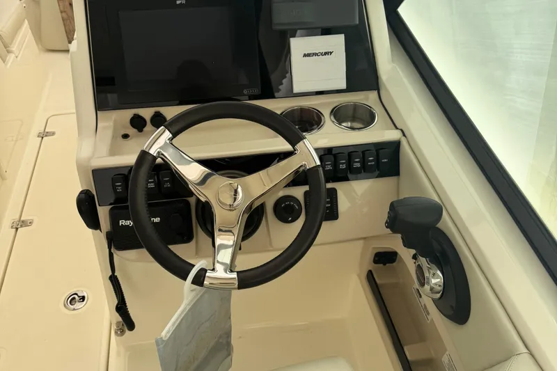 Slide: The Image of 2022 Boston Whaler 240 Vantage helm with steering wheel, controls, and navigation system. - 16