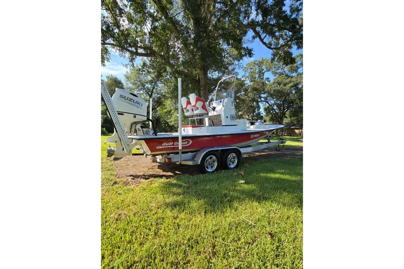 Slide: The Image of 2019 Gulf Coast Pro 22 boat on trailer, featuring Suzuki outboard motor, parked on grass. - 5