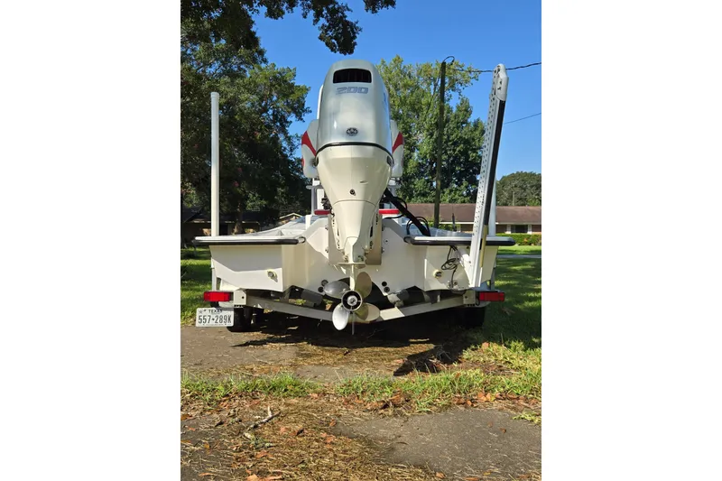 Slide: The Image of 2019 Gulf Coast Pro 22 boat with outboard motor on trailer, parked outdoors. - 8