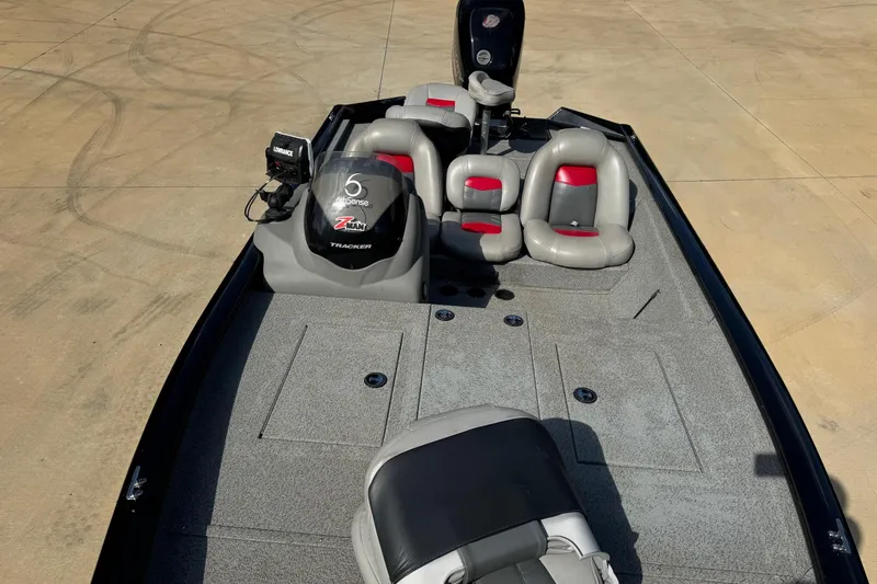 Slide: The Image of 2017 Bass Tracker PRO TEAM 190 boat with gray and red seating on a concrete surface. - 5