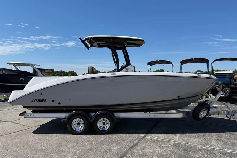 Slide: The Image of 2026 Yamaha Boats 255 FSH Sport H on trailer, side view under clear sky. - 0