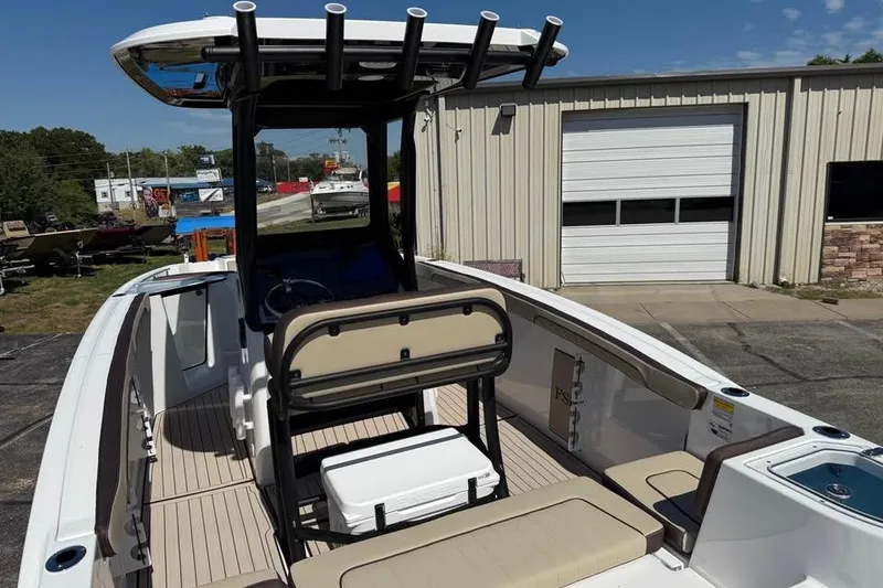 Slide: The Image of 2026 Yamaha Boats 255 FSH Sport H interior with seating and console, docked outdoors. - 7