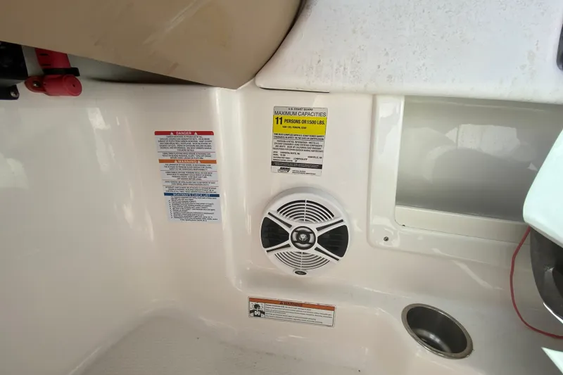 Slide: The Image of Interior of 2020 Chaparral 19 SSi boat showing speaker, warning labels, and cup holder. - 10