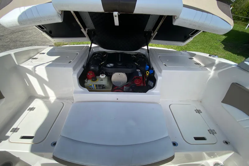 Slide: The Image of 2020 Chaparral 19 SSi boat engine compartment with open hatch, showcasing engine details. - 12