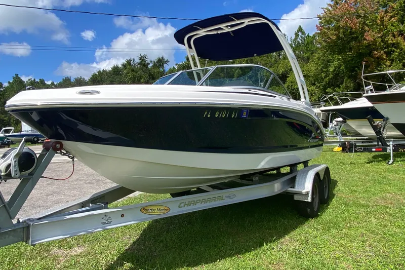 Slide: The Image of 2020 Chaparral 19 SSi boat on trailer, parked on grass under blue sky. - 3