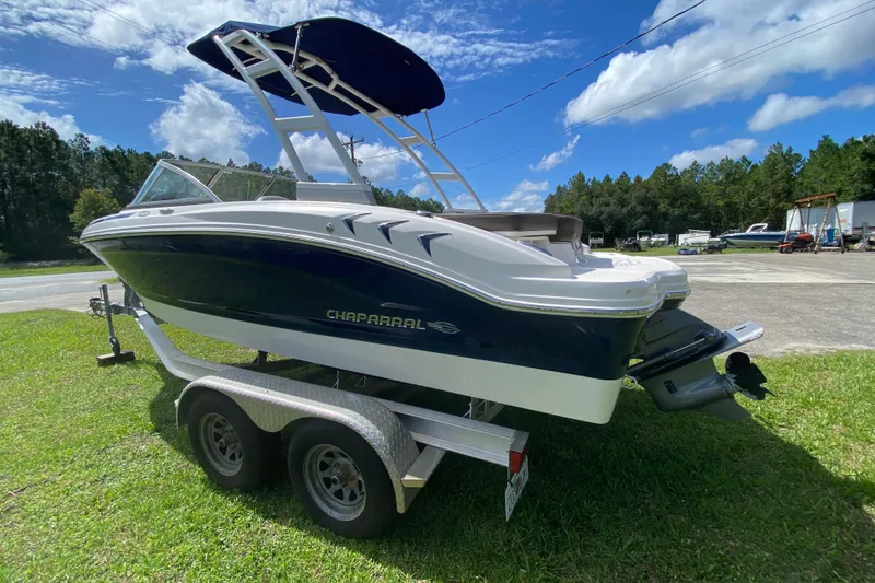 Slide: The Image of 2020 Chaparral 19 SSi boat on trailer, parked on grass under blue sky. - 4