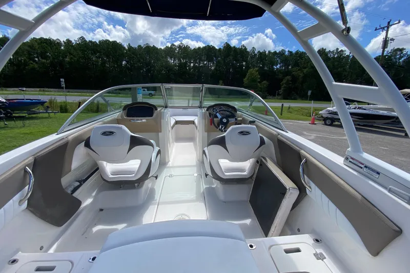 Slide: The Image of 2020 Chaparral 19 SSi boat interior with seating and steering wheel, under a blue sky. - 6