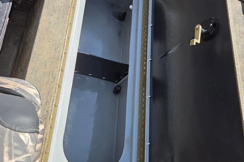 Slide: The Image of 2021 G3 Sportsman 1710 boat interior storage compartment with latch and camo seat. - 10