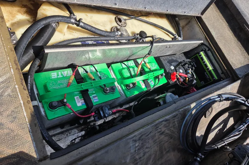 Slide: The Image of 2021 G3 Sportsman 1710 boat battery compartment with green batteries and wiring. - 8