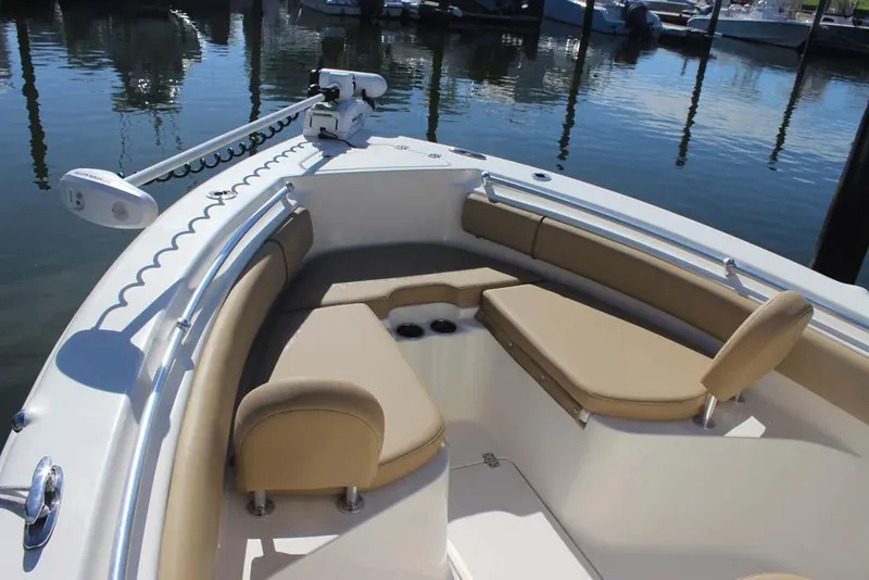 Slide: The Image of 2017 Key West 239 FS boat interior with tan seating and railings at a marina. - 10