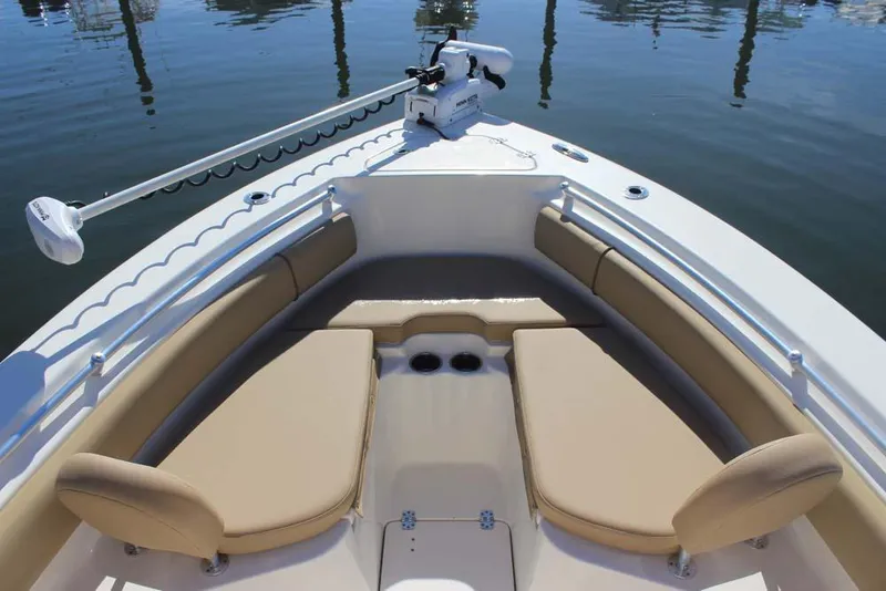 Slide: The Image of 2017 Key West 239 FS boat with tan seating and trolling motor on calm water. - 11