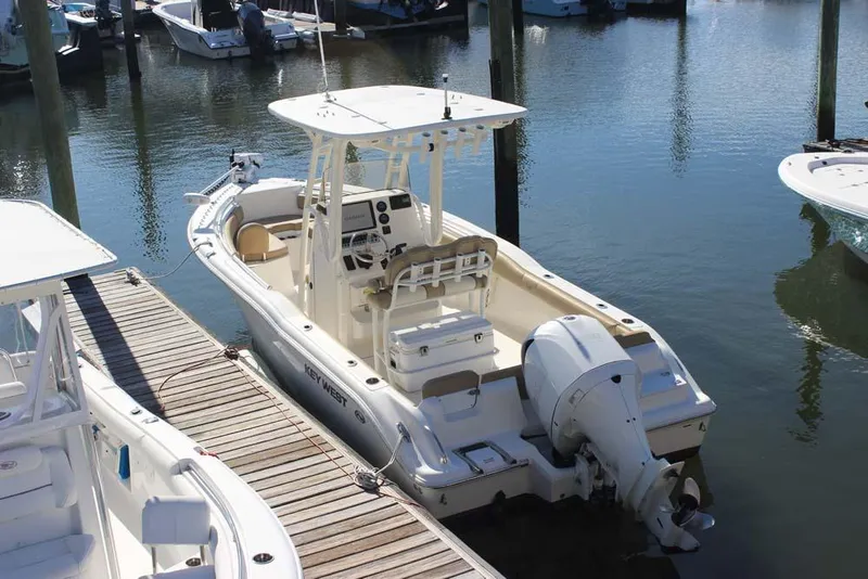 Slide: The Image of 2017 Key West 239 FS boat docked at marina, featuring outboard motor and center console. - 4