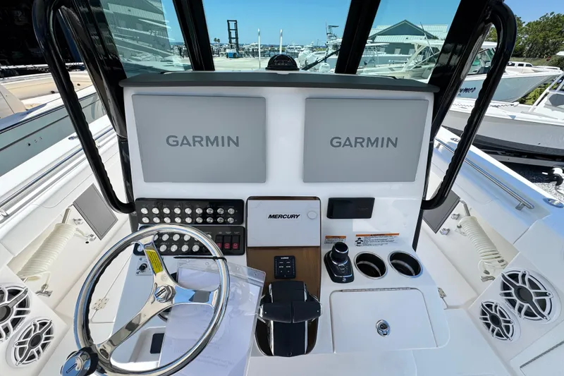 Slide: The Image of 2026 Caymas 34 CT boat dashboard with dual Garmin displays and Mercury controls. - 17