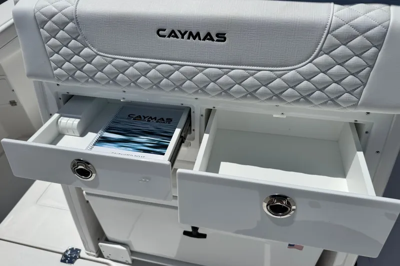 Slide: The Image of 2026 Caymas 34 CT boat interior with open storage drawers and manual. - 28