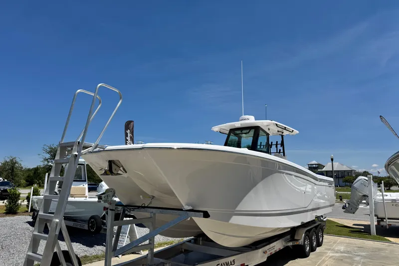 Slide: The Image of 2026 Caymas 34 CT boat on trailer under clear blue sky. - 6