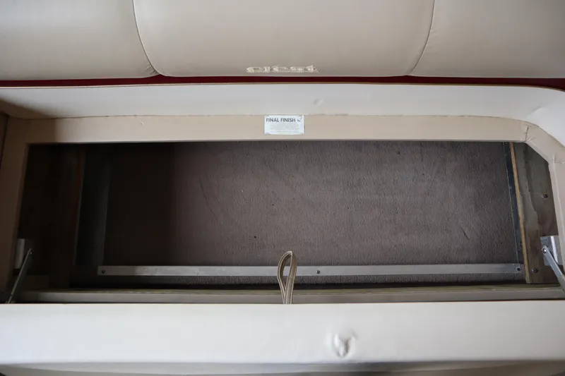 Slide: The Image of 1997 Crest 25 Caribbean boat interior storage compartment with beige upholstery. - 10