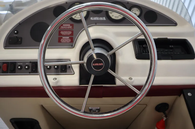 Slide: The Image of Steering wheel of a 1997 Crest 25 Caribbean boat with dashboard controls. - 13