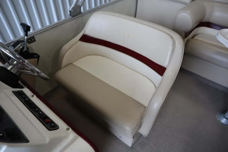 Slide: The Image of 1997 Crest 25 Caribbean boat interior with beige and maroon seating, steering wheel, and controls. - 22