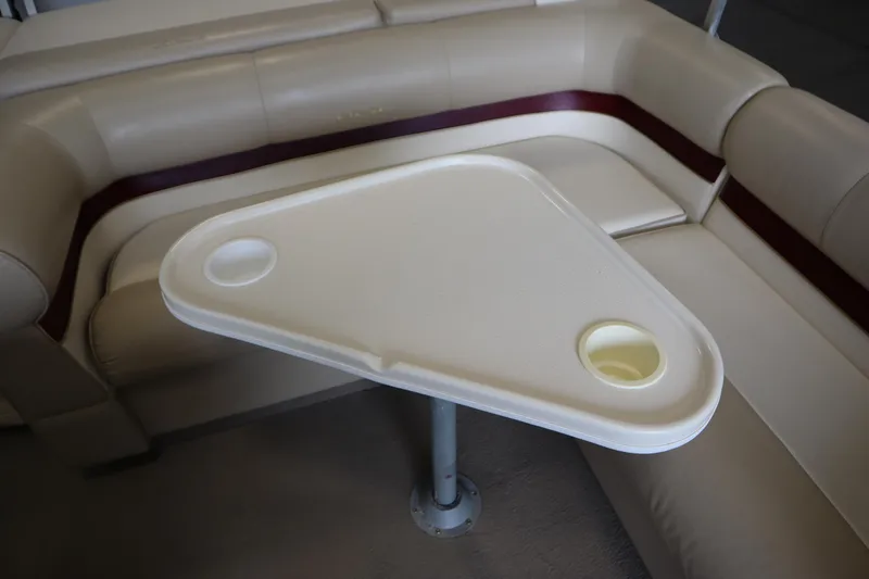 Slide: The Image of Interior of 1997 Crest 25 Caribbean boat with beige seating and triangular table. - 28