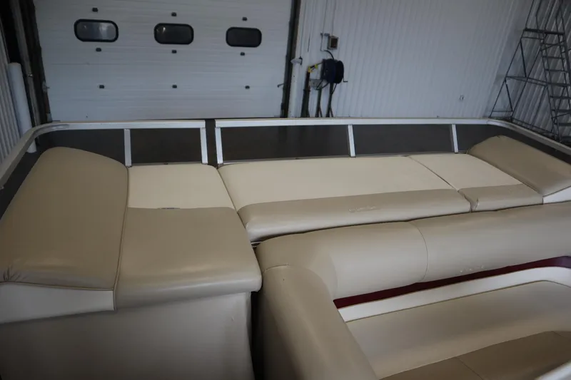 Slide: The Image of 1997 Crest 25 Caribbean boat interior with beige seating in a garage setting. - 29