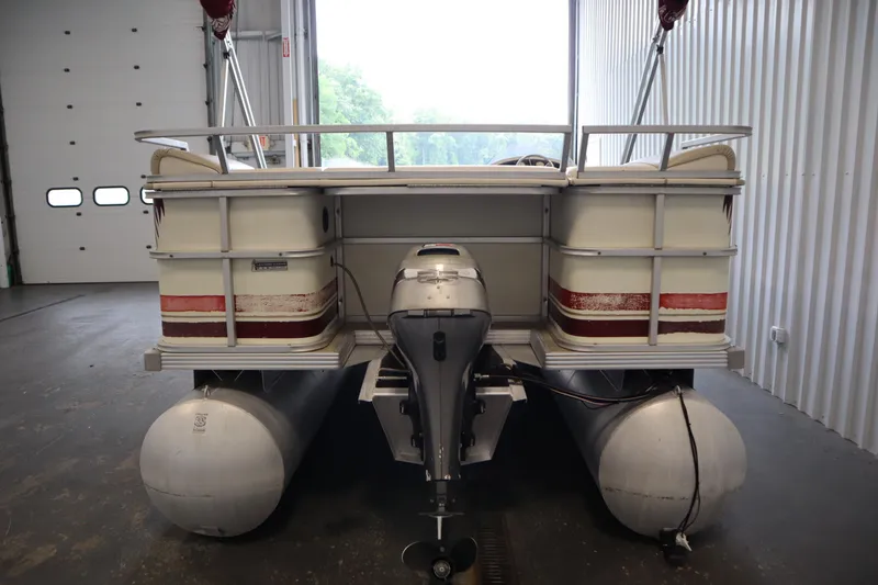Slide: The Image of 1997 Crest 25 Caribbean pontoon boat with outboard motor in a storage facility. - 3