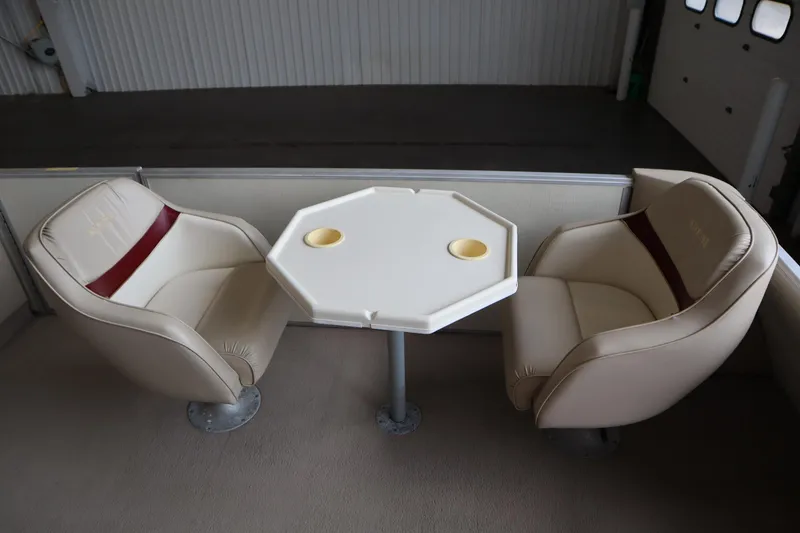 Slide: The Image of Interior of a 1997 Crest 25 Caribbean boat with beige seating and a small table. - 8