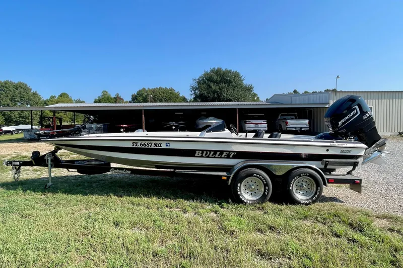 The Image of 2000 Bullet 21XD boat with Mercury engine on trailer, parked outdoors. - 0
