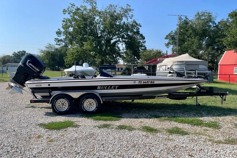 Slide: The Image of 2000 Bullet 21XD boat with Mercury engine on trailer, parked outdoors. - 1
