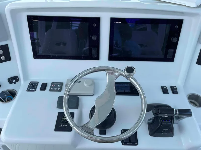 Slide: The Image of Control panel of a 2014 Yellowfin 42 boat with dual screens and steering wheel. - 12