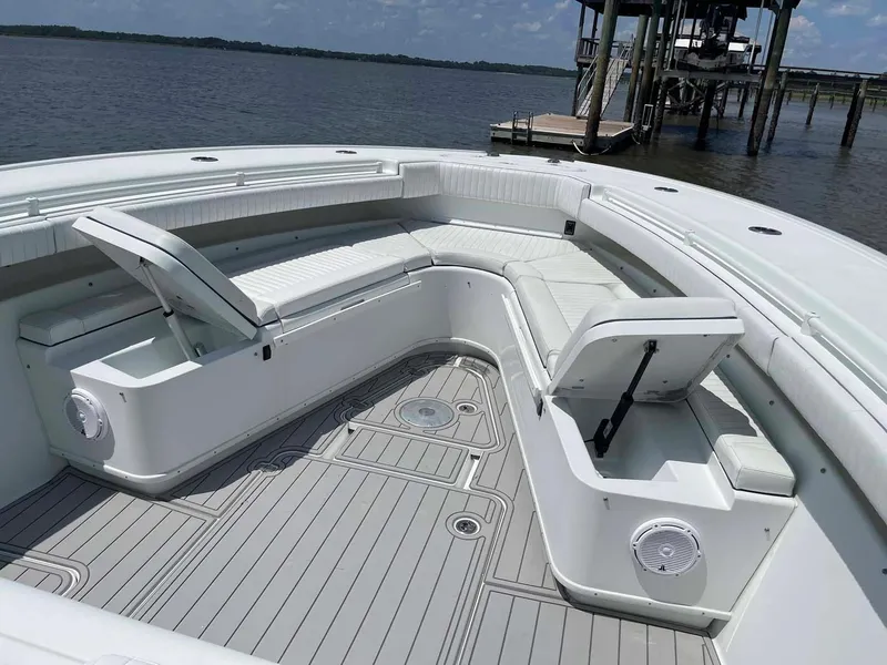 Slide: The Image of 2014 Yellowfin 42 boat with spacious seating and storage, docked by a serene waterfront. - 2
