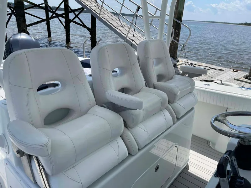 Slide: The Image of 2014 Yellowfin 42 boat with three plush white seats, docked by the water. - 21
