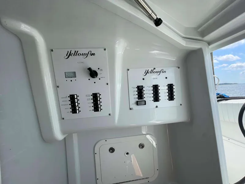 Slide: The Image of Control panel of a 2014 Yellowfin 42 boat with switches and dials. - 22