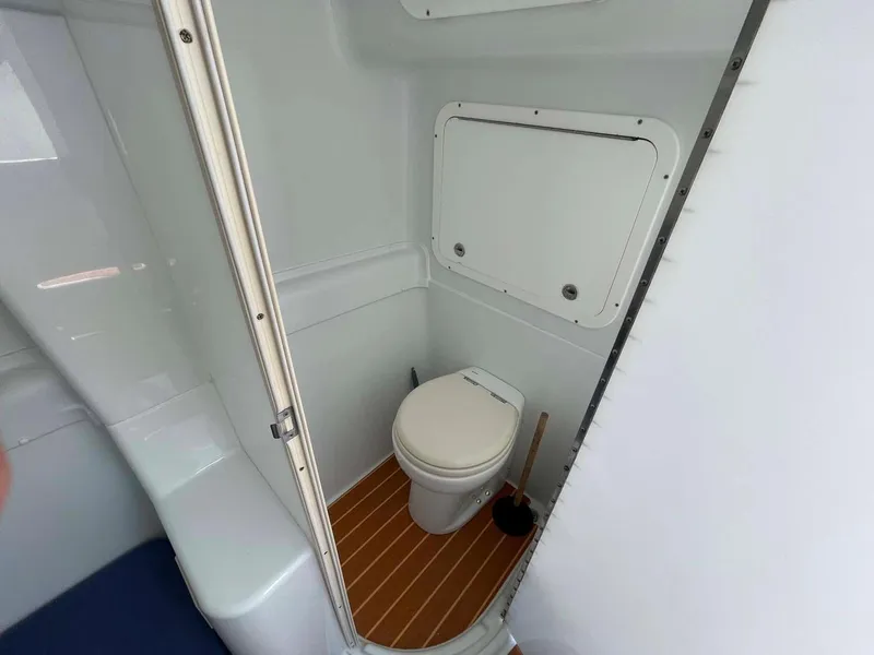 Slide: The Image of 2014 Yellowfin 42 boat bathroom with white interior and wooden floor. - 24