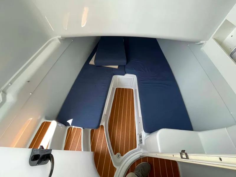Slide: The Image of 2014 Yellowfin 42 cabin interior with blue cushions and wooden flooring. - 25