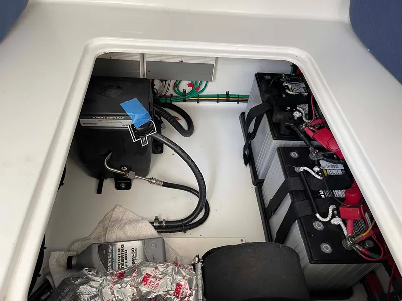 Slide: The Image of 2014 Yellowfin 42 boat battery compartment with wiring and maintenance supplies. - 34