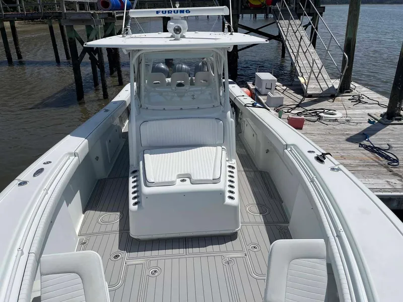 Slide: The Image of 2014 Yellowfin 42 boat docked, featuring spacious deck and seating area. - 7
