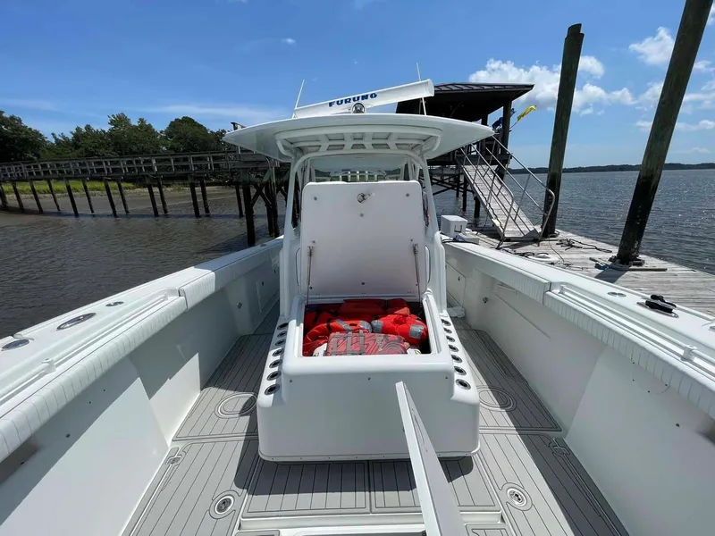 Slide: The Image of 2014 Yellowfin 42 boat docked, open storage with life jackets, sunny day. - 8