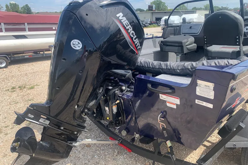 Slide: The Image of 2024 Tracker Pro Guide V-16 WT boat with Mercury outboard motor, parked on gravel. - 2