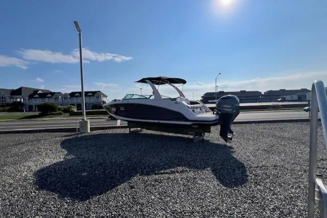 Slide: The Image of 2018 Four Winns HD270 OB boat displayed outdoors on gravel under a clear blue sky. - 4