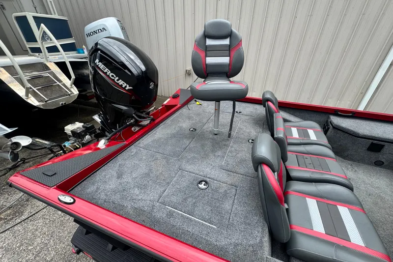 Slide: The Image of 2024 Bass Tracker RT178 boat interior with Mercury engine, featuring gray and red seating. - 14