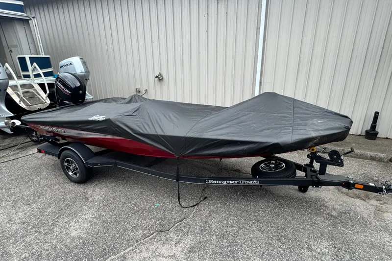 Slide: The Image of 2024 Bass Tracker RT178 boat covered on trailer, parked outdoors. - 22