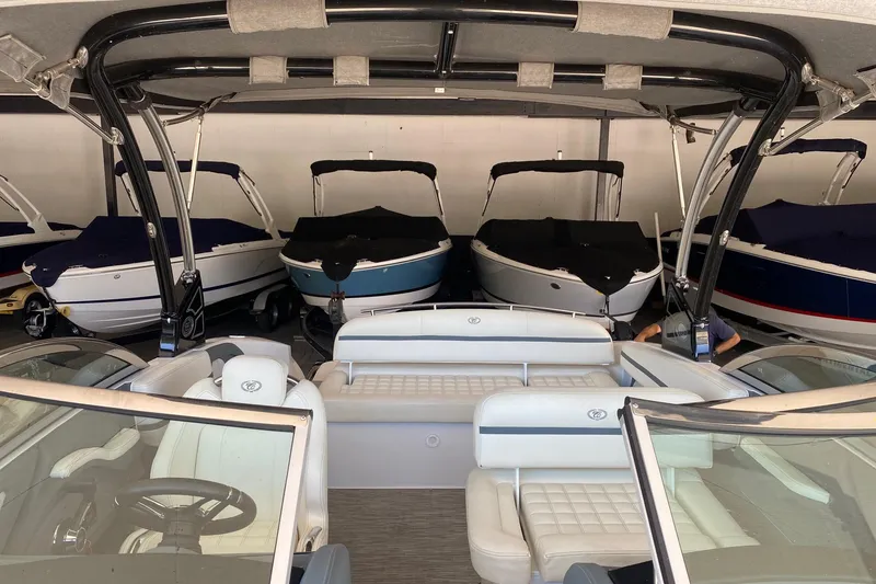 Slide: The Image of 2021 Cobalt R3 boat interior in showroom with multiple covered boats in background. - 7