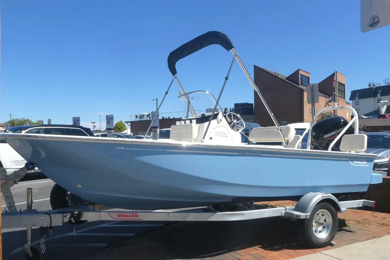 The Image of 2026 Boston Whaler 170 Montauk boat on trailer, parked outdoors under clear blue sky. - 0